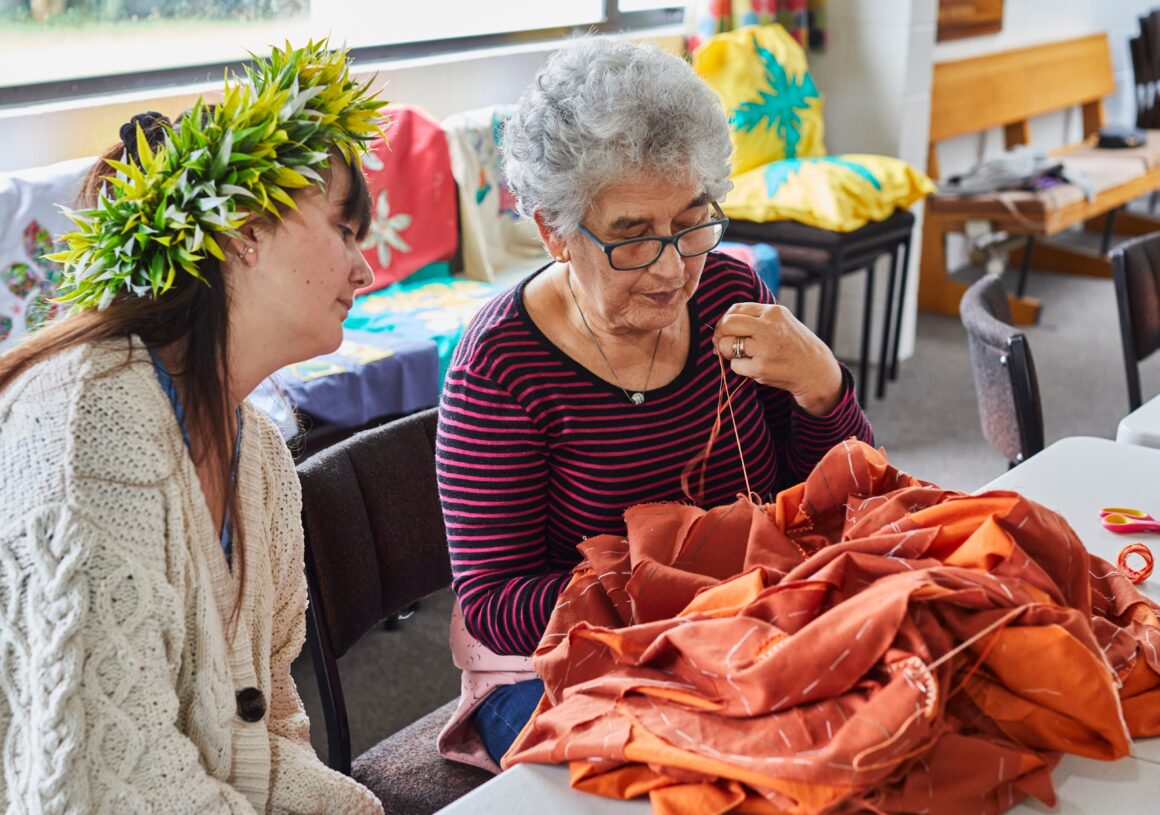 Pia watches as Berry tacks the contrasting pattern to the base fabric,
a skilled step needed before the blanket stitching begins